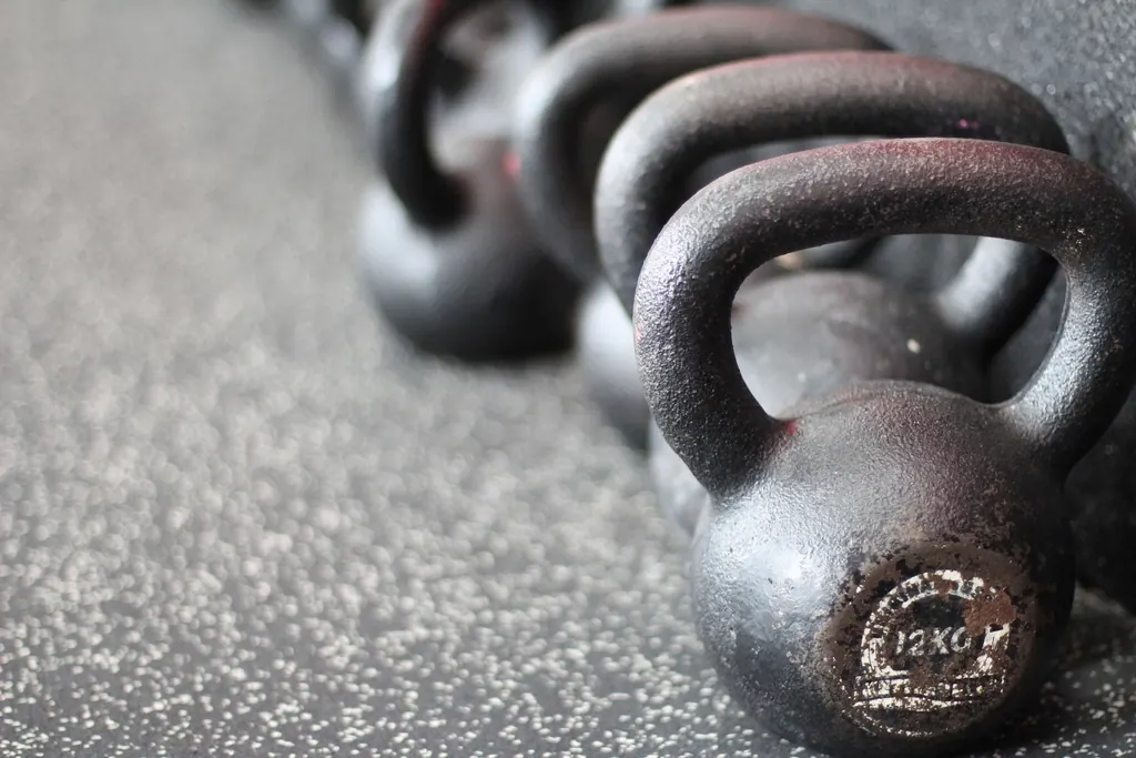 Fila de kettlebells de hierro sobre suelo de gimnasio